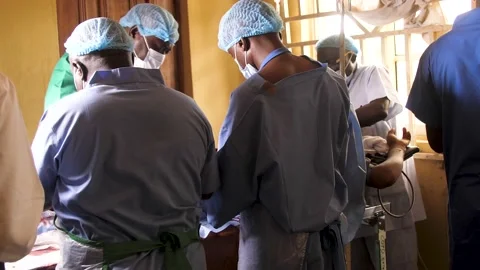 Team of surgeons in operating theater performing operation on a patient . Stockbeeldmateriaal 165384535
