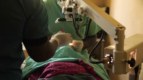 Team of surgeons in operating theater performing operation on a patient . Stockbeeldmateriaal 165435307