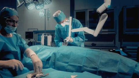 Team of surgeons perform a delicate operation using medical surgical robotic arm Vídeo Stock 125284227