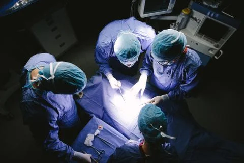 Team of surgeons performing surgery in operation theater Stock Photos