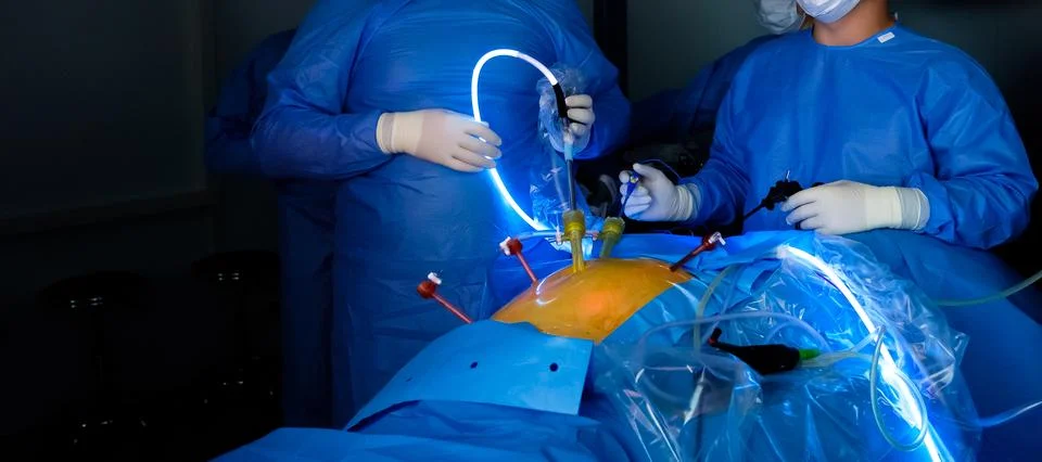A team of surgeons performs laparoscopic surgery. Stock Photos