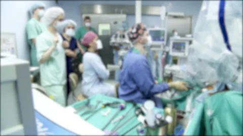 A team of surgeons performs an operation using a medical robot. Blurred video. Stock Footage 148415762