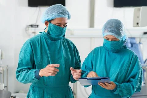 Team of surgeons reading document Stock Photos