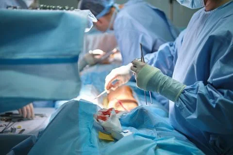 Team of surgery doctors operating a patient in surgical room. Healthcare and Photos