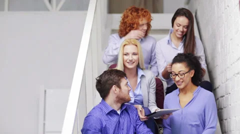 Team with tablet pc computer sitting on staircase Stock Footage 36645481