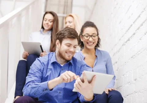 Team with tablet pc computer sitting on staircase Foto stock