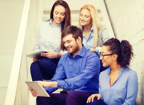 Team with tablet pc computer sitting on staircase 스톡 사진