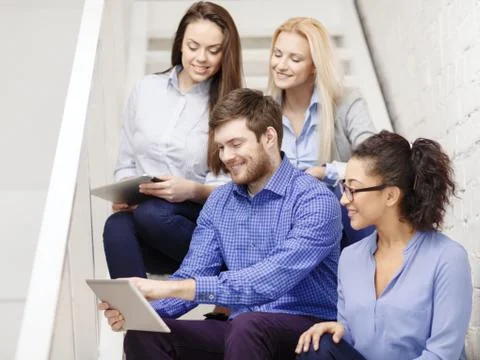 Team with tablet pc computer sitting on staircase Stock Photos