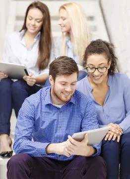 Team with tablet pc computer sitting on staircase 스톡 사진