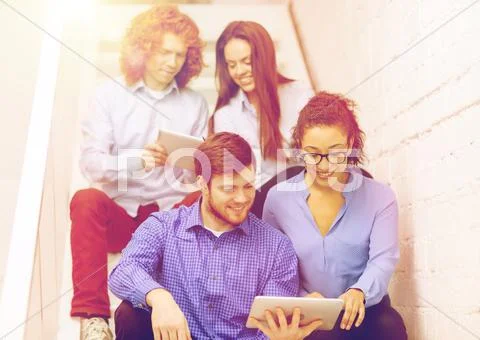 Team with tablet pc computer sitting on staircase Stock Photos