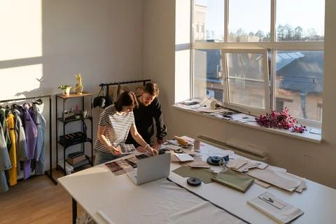 Team of tailor designers work on clothes collection: choose fabric with pattern Stock Photos