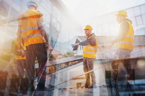 Team of technical workers work on the roof of a house Stock Photos