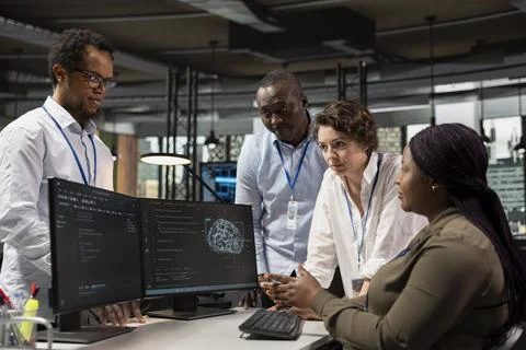 Team of technicians in office automating repetitive tasks using AI Stock Photos
