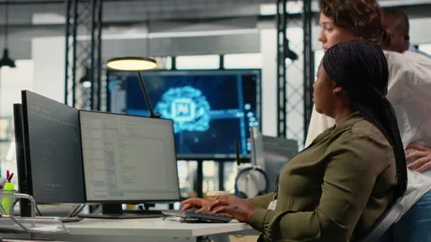 Team of technicians in office working together, automating workflows using AI Video stock 323239631