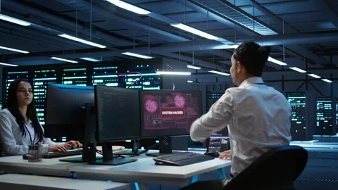 Team of technicians in server hub alerted by hacker passing firewall Stock Footage 280802570