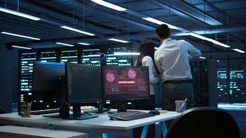 Team of technicians in server hub alerted by hacker passing firewall Stock Photos