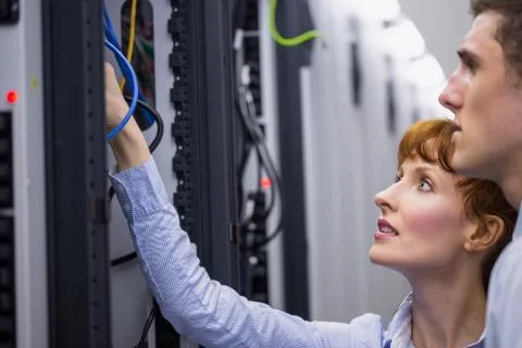 Team of technicians talking and looking at server Stock Photos
