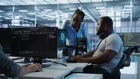 Team of technicians using PC to check for system failures in data center Stock Photos