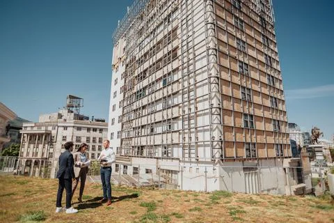 Team of three architects discussing progress of building Fotos de archivo