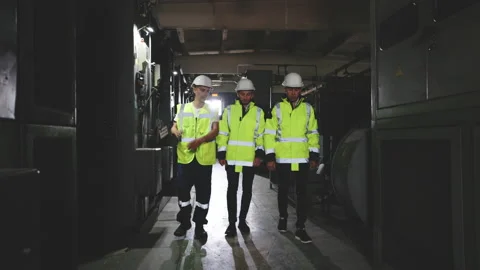 Team of three engineers walking through electricity power station. Electrical Stock Footage 194614462