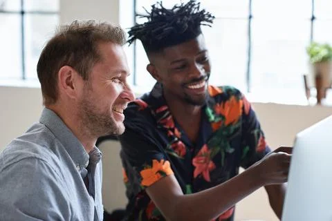 Team, training and men at computer with smile for advice, help or feedback at cr Stock Photos
