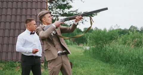 Team of two men shooting the gun, they wear old retro clothes as gangsters Stock Footage 164704141