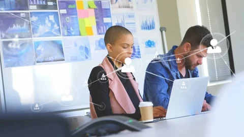 Team typing at laptops, node near left laptop starting overlay spreading over Video stock 332275683