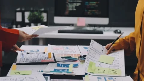 Team of uxui designers pointing at computer screen, discussing new mobile a.. Stock Footage 322712582