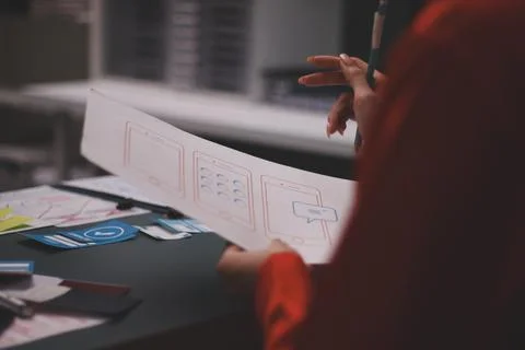 Team of uxui designers pointing at computer screen, discussing new mobile a.. Stockfoto's