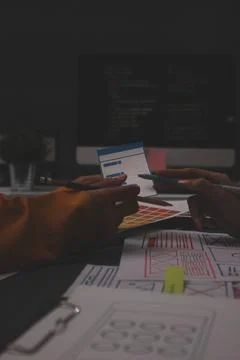 Team of uxui designers pointing at computer screen, discussing new mobile a.. 写真素材