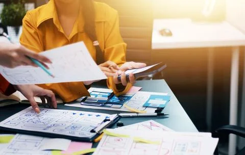 Team of uxui designers pointing at computer screen, discussing new mobile a.. Foto stock
