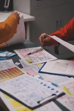 Team of uxui designers pointing at computer screen, discussing new mobile a.. Foto stock
