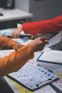Team of uxui designers pointing at computer screen, discussing new mobile a.. Foto stock