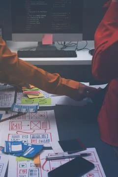 Team of uxui designers pointing at computer screen, discussing new mobile a.. 库存照片