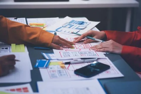 Team of uxui designers pointing at computer screen, discussing new mobile a.. 库存照片