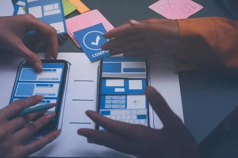 Team of uxui designers pointing at computer screen, discussing new mobile a.. 스톡 사진