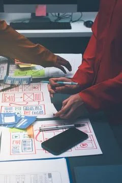 Team of uxui designers pointing at computer screen, discussing new mobile a.. Stock Photos