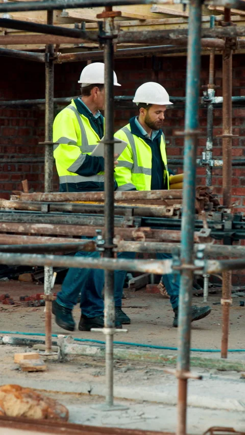 Team, walk and talk at construction site with engineering update, scaffolding or Stock Footage 336198785