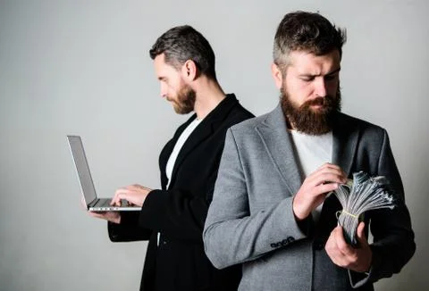 Team of web developer with laptop and sales manager with cash money. Developing Stock Photos