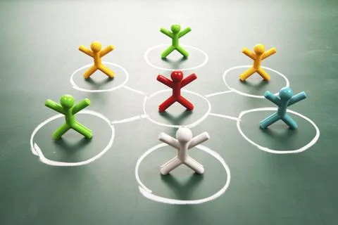 Team work concept. Coloful dolls on blackboard. Stock Photos