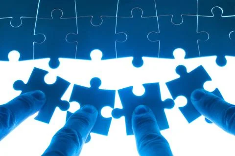 Team work on solving puzzle problem Team work on solving puzzle problem. T... Stock Photos