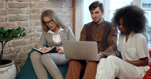 Team work of three multirace businesspeople working on the laptop and laughing Stock Footage 84038583