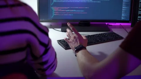 Team work of two programmers who are sitting in front of computer screen and Stock Footage 151719545