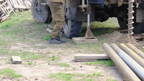 Team of workers with drilling rig on car are drilling artesian well for water Stock Footage 201295398