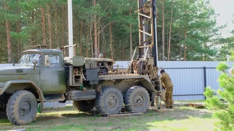 Team of workers with drilling rig on car are drilling artesian well for water Stock Footage 201295634
