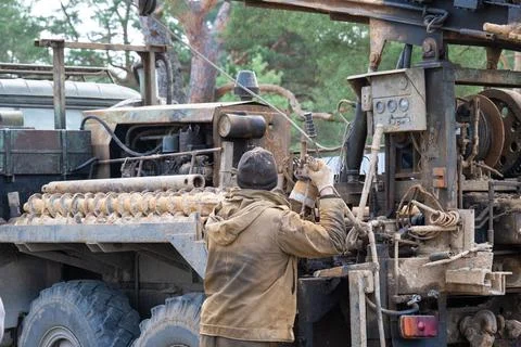 Team of workers with drilling rig on car are drilling artesian well for wat.. Stock Photos