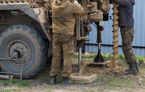 Team of workers with drilling rig on car are drilling artesian well for wat.. Stock Photos