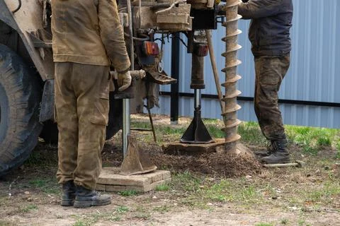 Team of workers with drilling rig on car are drilling artesian well for wat.. Stock Photos