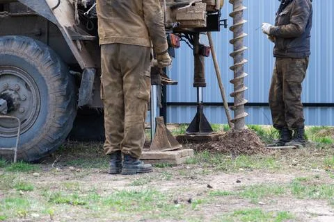 Team of workers with drilling rig on car are drilling artesian well for wat.. Stock Photos
