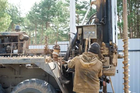 Team of workers with drilling rig on car are drilling artesian well for wat.. Stock Photos
